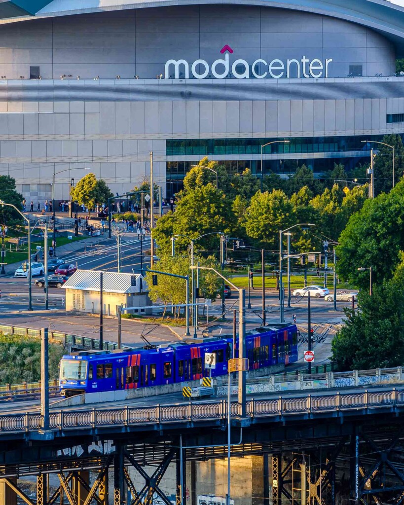 Exterior view of the Moda Center with a train passing in the foreground, Portland, Oregon, USA