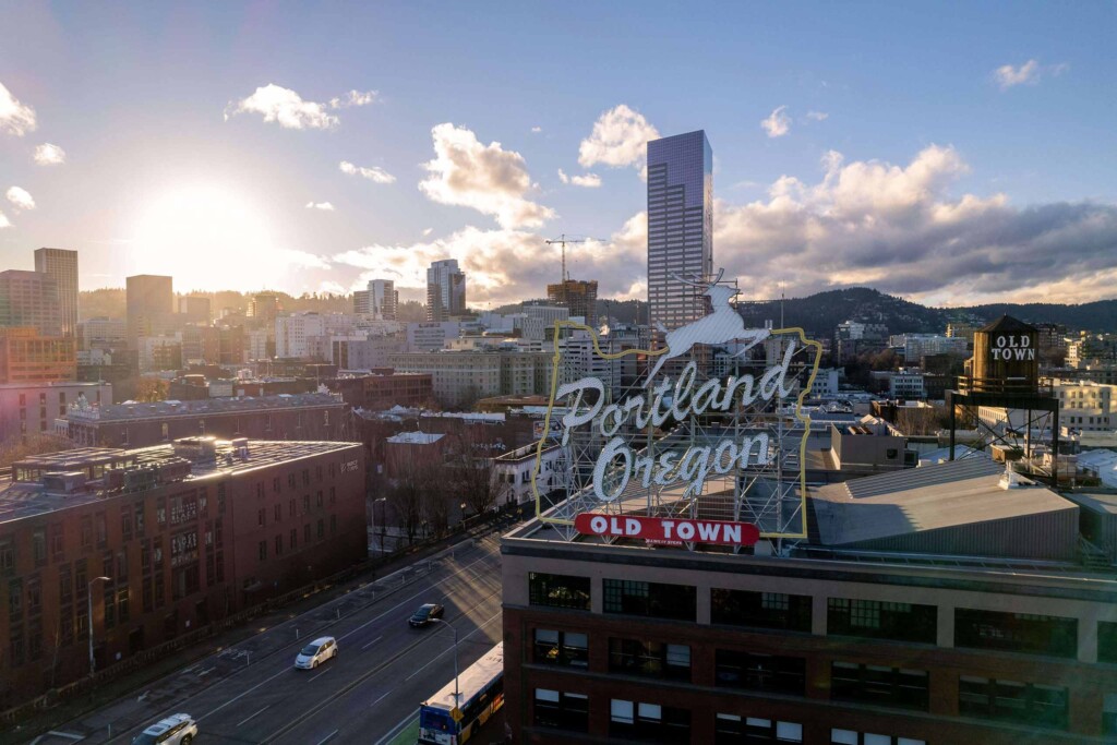 View over the skyline with a sign in the foreground reading 'Portland, Oregon Old Town'