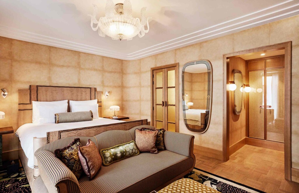 Retro-inspired furnishings in soft beige tones and a chandelier oozing diffused light into the space inside a bedroom, Sommerro, Oslo, Norway