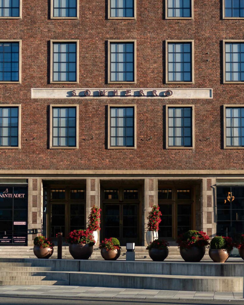 Potted plants outside the modernist, brown brick facade of Sommerro, Oslo, Norway